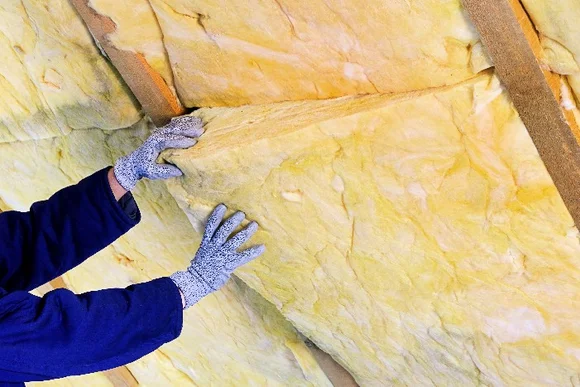 Person dämmt Dachboden